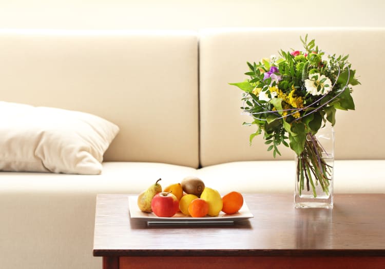 Bouquet of flowers and a plate of fruit on the coffee table in a model home at Mezza in Jacksonville, Florida
