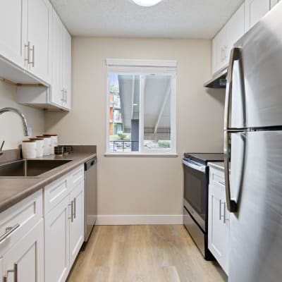 Fully equipped kitchen with stainless steel appliances in a model home at Haven Apartment Homes in Kent, Washington