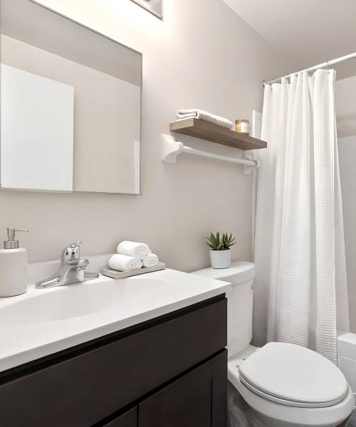 Modern bathroom with white countertops at Pleasant View Townhomes in Baltimore, Maryland