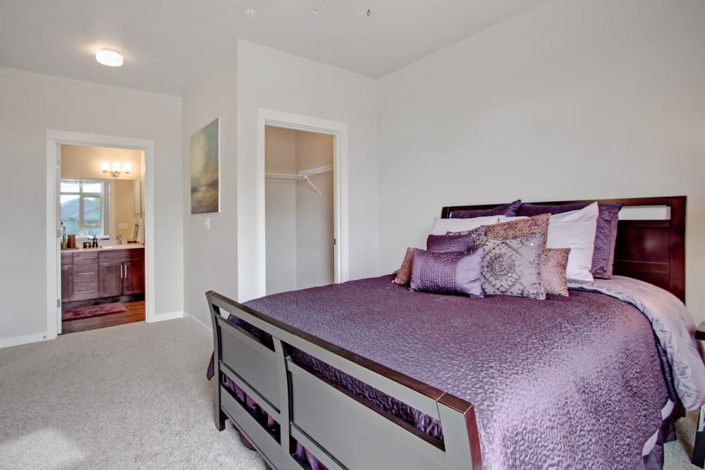 Model bedroom with ensuite bathroom and wardrobe closet at Motif Apartments in Lynnwood, Washington