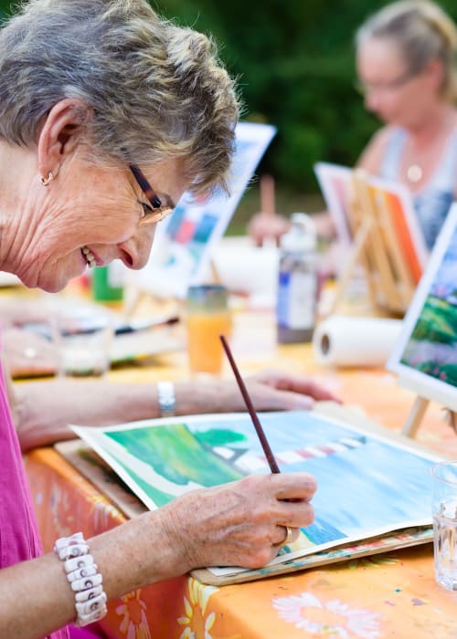 Group of residents outdoors painting at Liberty Arms Assisted Living in Youngstown, Ohio