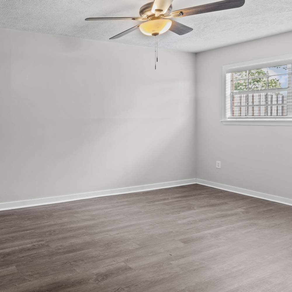 Spacious and airy bedroom with a modern ceiling fan and ample natural light at Pecan Ridge in Vicksburg, Mississippi.