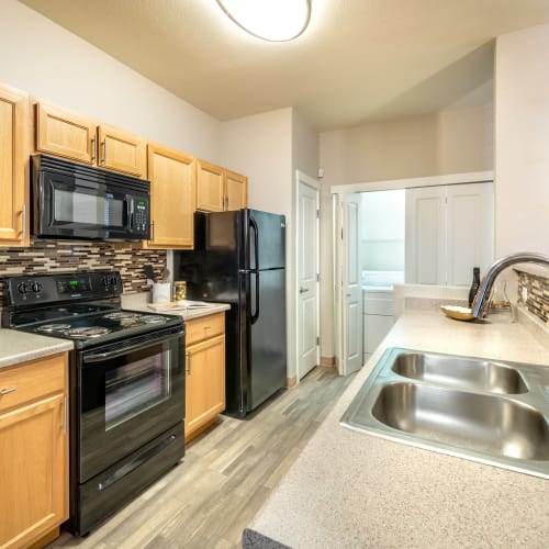 Gourmet kitchen with a dual-basin sink and quartz countertops in a model home at Olympus Solaire in Albuquerque, New Mexico