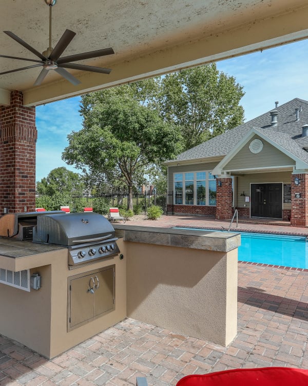 Poolside covered BBQ with bar top seating at Promenade at Hunter's Glen Apartments in Thornton