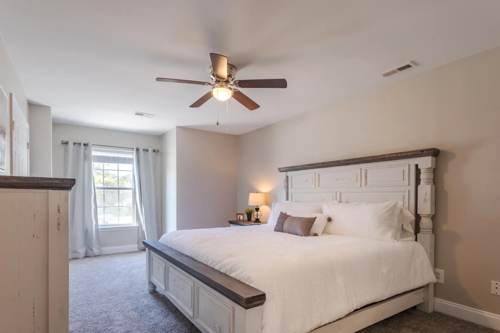 Spacious bedroom with a large bed and ceiling fan at Avalon II Apartments in Charleston, South Carolina