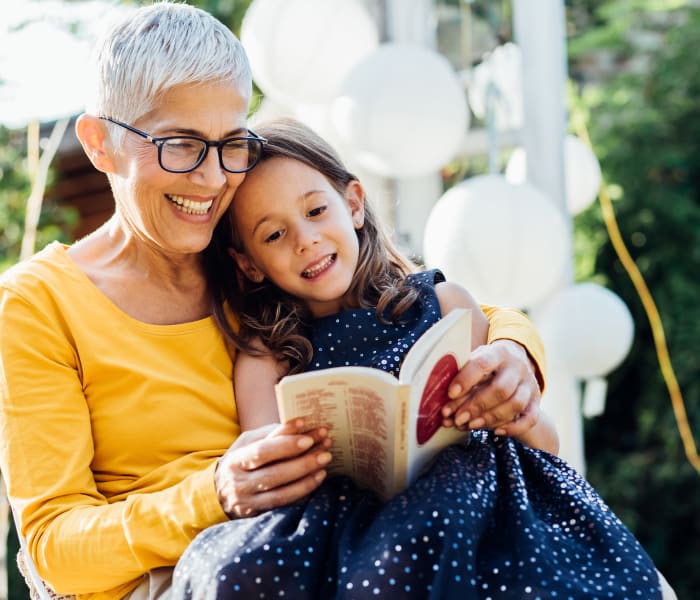 Resident reading with a young child at a Radiant Senior Living community