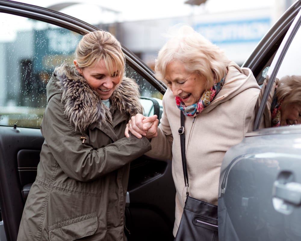 A caretaker assisting a resident out of a car at The Harmony Collection at Columbia Assisted Living & Memory Care in Columbia, South Carolina