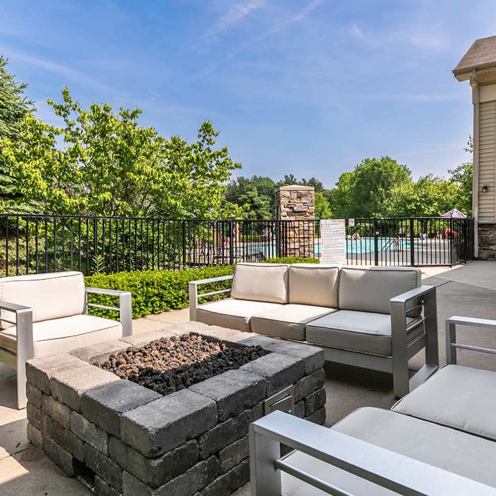 Outdoor seating area with fire pit overlooking resort-style pool and greenery at 43 North Apartments in Grand Haven, Michigan