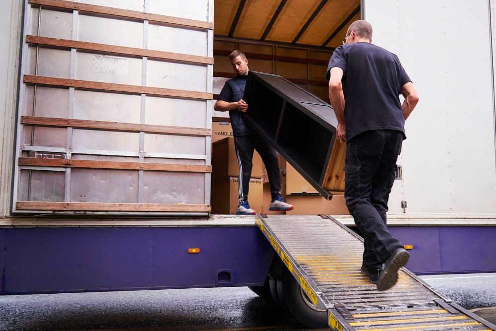 Two men loading furniture into a moving truck at A-American Self Storage in Honolulu, Hawaii