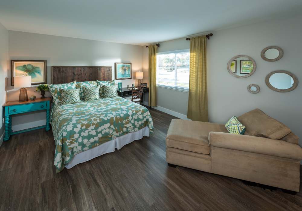 Spacious bedroom with large comfortable bed and windows at Harbor Cove Apartments in Foster City, California,