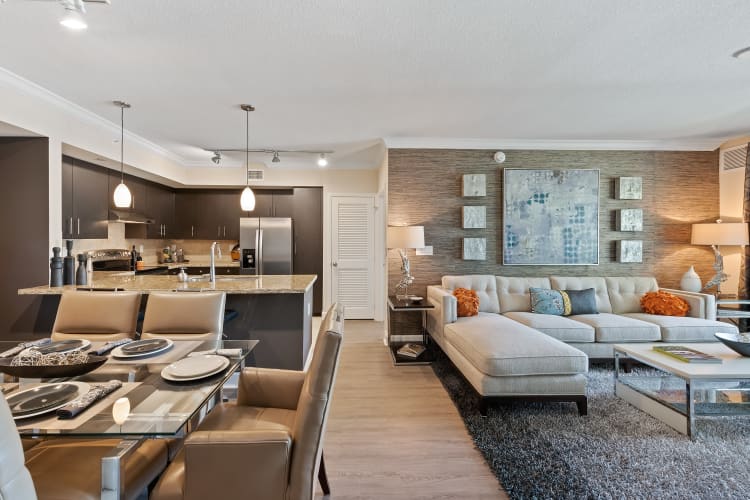 Open concept living room, dining room, and kitchen in a luxury apartment home at The Residences at Lakehouse in Miami Lakes, Florida