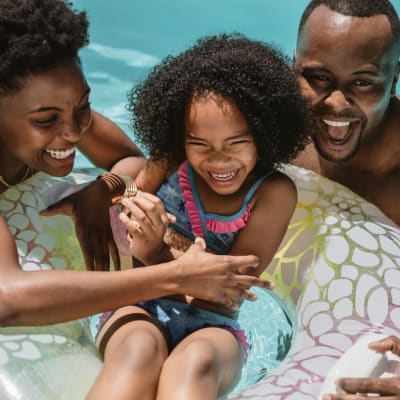 A family playing in a swimming pool at Santa Cruz in Point Mugu, California