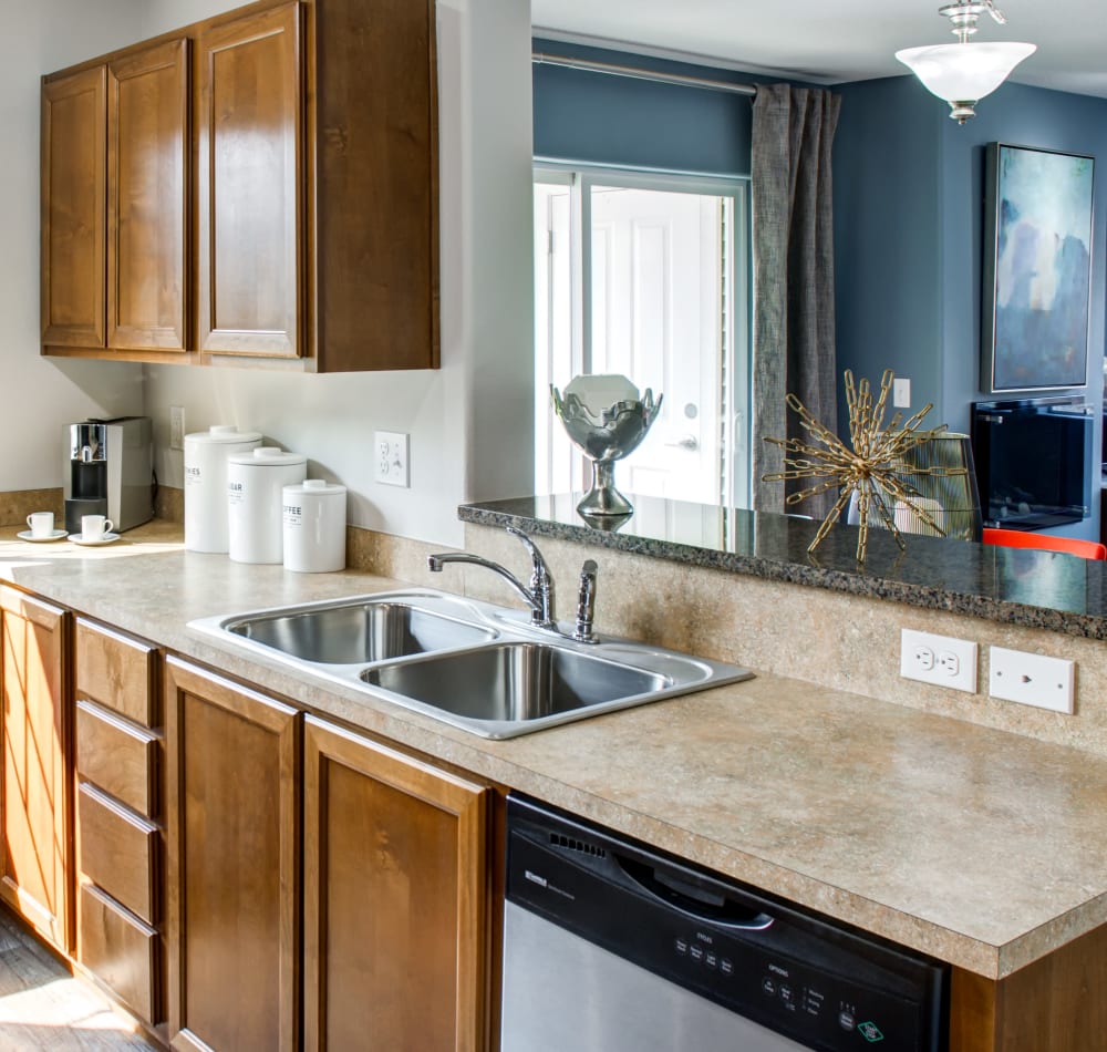 Modern kitchen with granite countertops and a breakfast bar in a model home at Sofi at Cedar Mill in Portland, Oregon