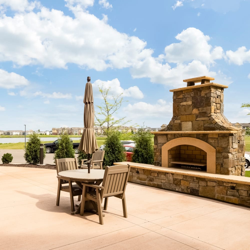 Outdoor community space with fireplace at Applewood Pointe of Maple Grove at Arbor Lakes in Maple Grove, Minnesota.