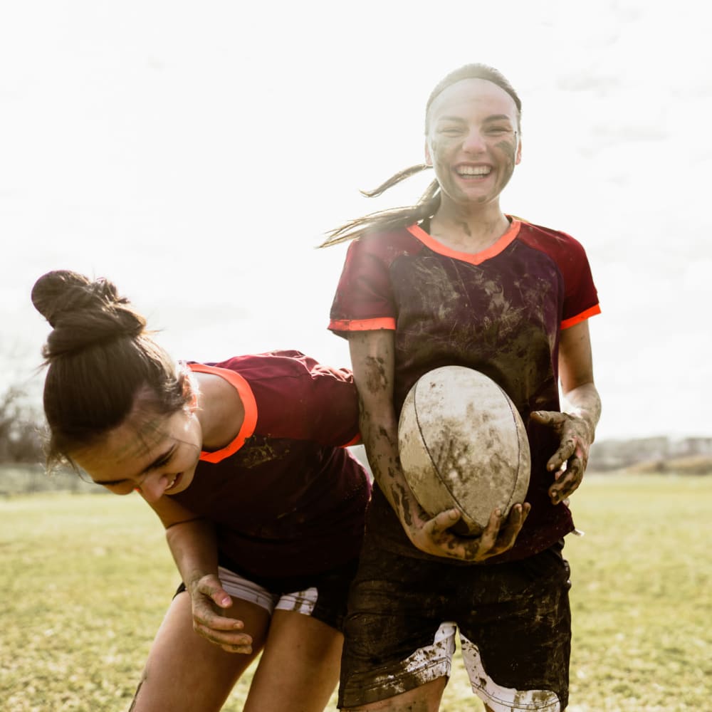 Friends playing rugby together and laughing near The Ivy in Tampa, Florida