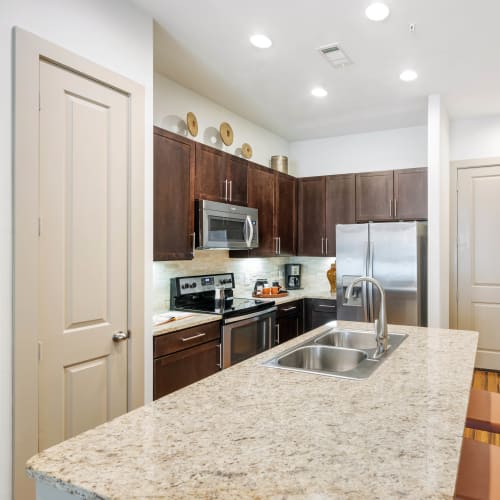 Gourmet kitchen with an island and pantry in a model home at Olympus Sierra Pines in The Woodlands, Texas