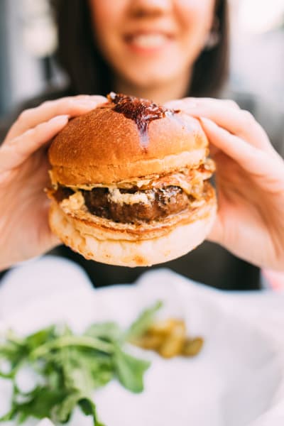 Resident showing a delicious burger at a restaurant near The BLVD in San Angelo, Texas