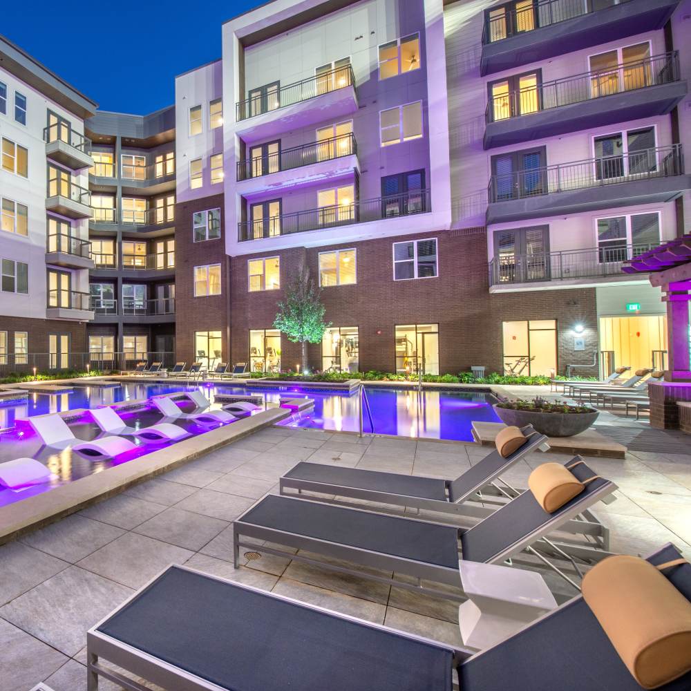 Luxurious lounge chairs beside the pool at Hall Street Flats in Dallas, Texas