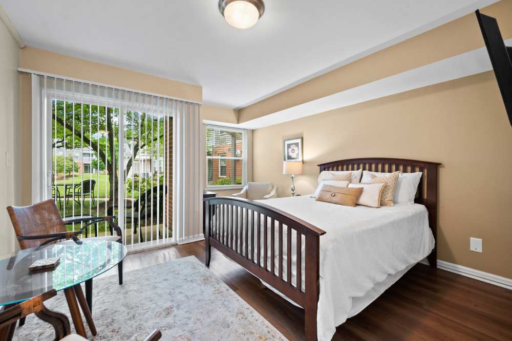 Bedroom with bed and sitting area overlooking a patio at Rollingcrest Commons in Hyattsville, Maryland