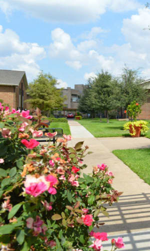 Walking path and flowers in the courtyard at Parkway Villas in Grand Prairie, Texas