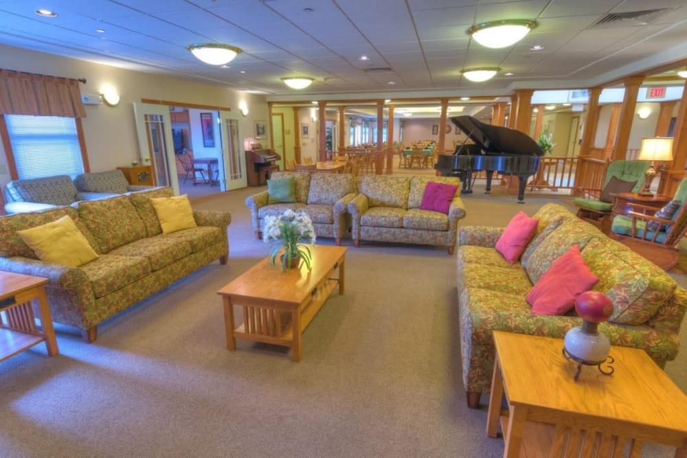 Common area with three sofas and seating in the background at Addington Place of Muscatine in Muscatine, Iowa