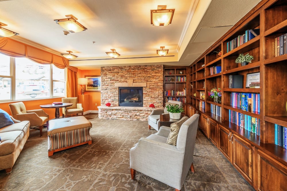 Reading room with seating and bookshelves at The Palisades at Broadmoor Park in Colorado Springs, Colorado