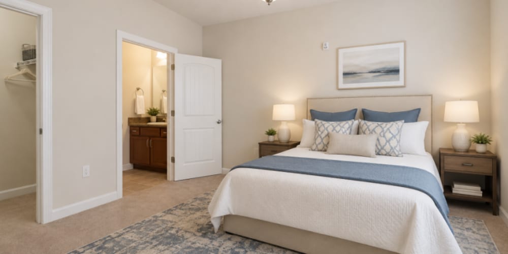 Furnished bedroom with ceiling fan and carpet flooring at Seasons at Cane Creek in Fletcher, North Carolina