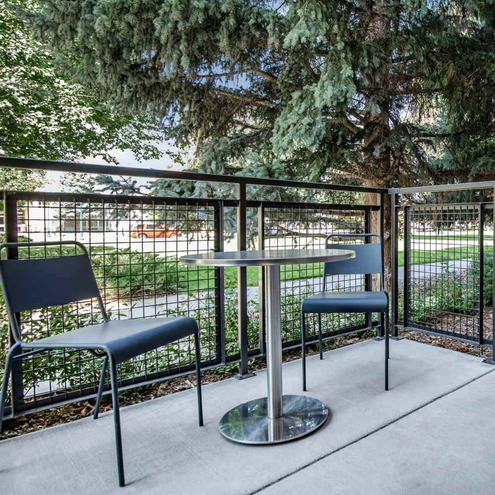 Private patio with chair and table at Park Place Olde Town Apartments in Arvada, Colorado