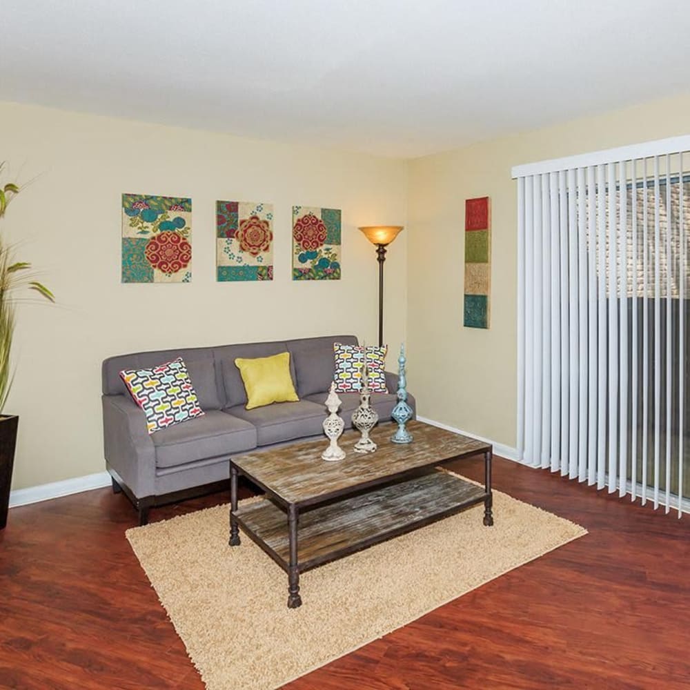 Hardwood-style flooring in the well-furnished living area of an apartment home at Mustang on the Trail in Kingwood, Texas