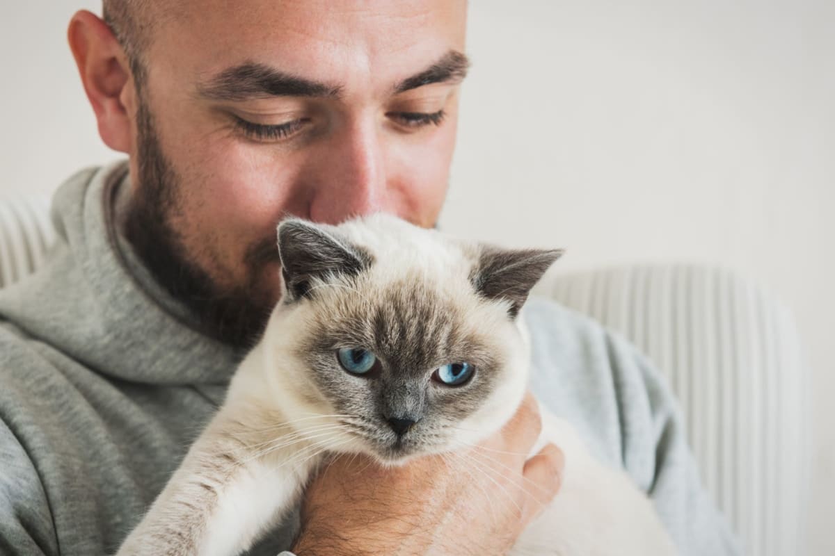 Resident holding his cute cat in his arms at Hawaiian Gardens in Washington, District of Columbia