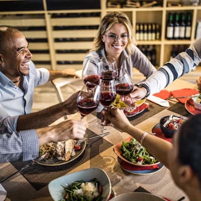 Friends smiling and having dinner at The Towne at Northgate Apartments in Colorado Springs, Colorado