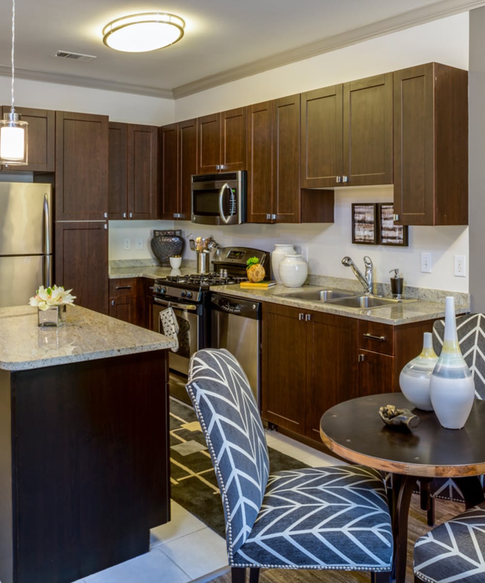 Dining table and kitchen with chef's island at 17 Barkley in Gaithersburg, Maryland