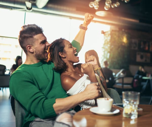 Couple cheering on their team at ML Steaks + Sports in Miami Lakes