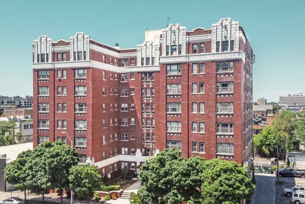 View of exterior of apartments and green lawn at Detroit Living in Detroit, Michigan