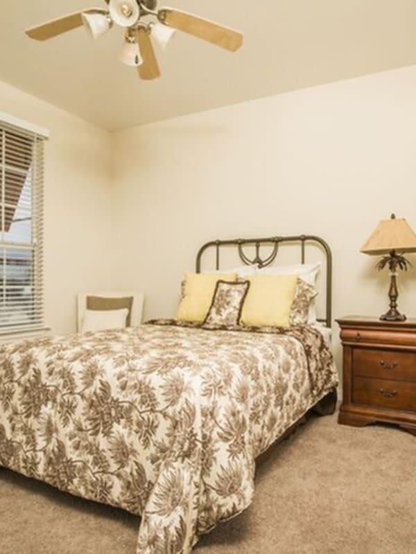 Model master bedroom with plush carpeting and a ceiling fan at Harborside Apartment Homes in Slidell, Louisiana