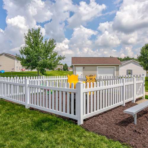 Playground with fence and benches at Orchard Glen in Orrville, Ohio