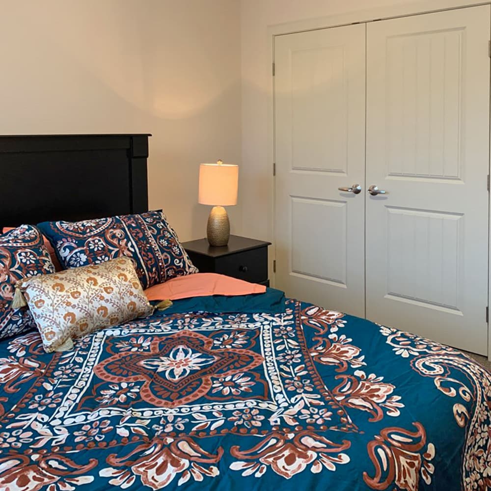 Comfortable bedroom with large bed, side lamp and closet at Depot on Main in Zimmerman, Minnesota