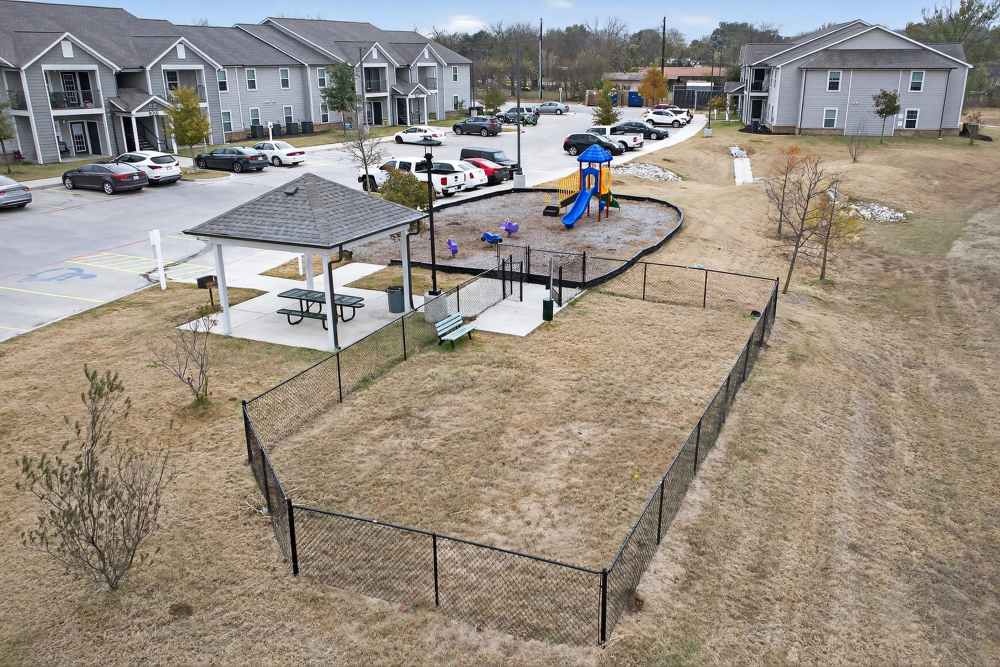 Spacious outdoor play area with a vibrant playground and inviting gazebo at Lakewood Crossing in Granbury, Texas.