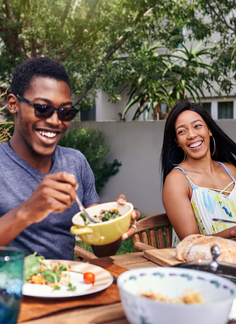 Residents enjoying a meal outside near Marquis at Great Hills in Austin, Texas