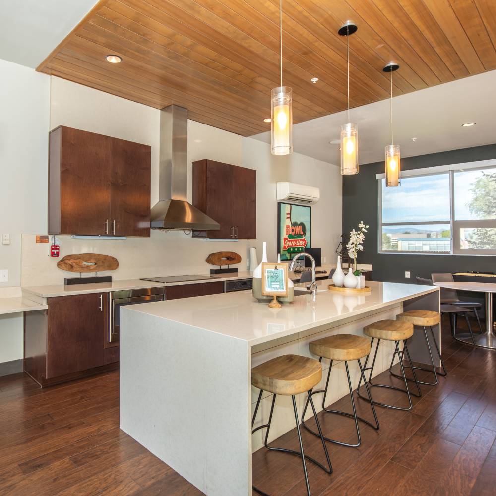 Community kitchen with island countertop and barstool at Park Place Olde Town Apartments in Arvada, Colorado