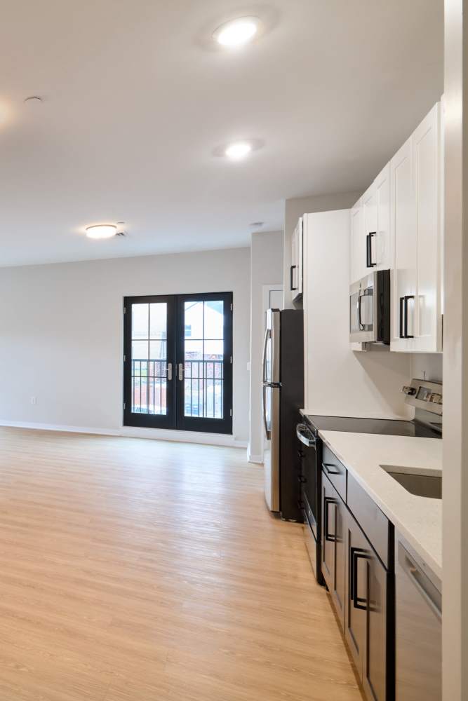 Spacious kitchen and living area with wood flooring in a model home at The Seville Apartments in Easton, Pennsylvania