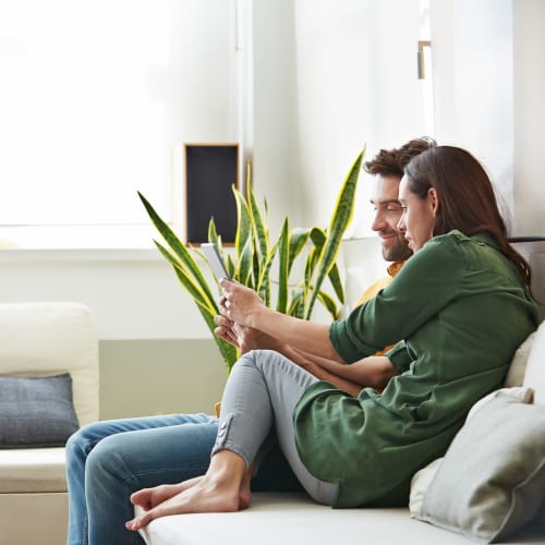 residents looking at a phone on their couch at Queens Way in Norfolk, Virginia