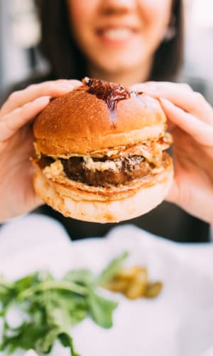 Resident eating a juicy burger near Pecan Ridge in Waco, Texas