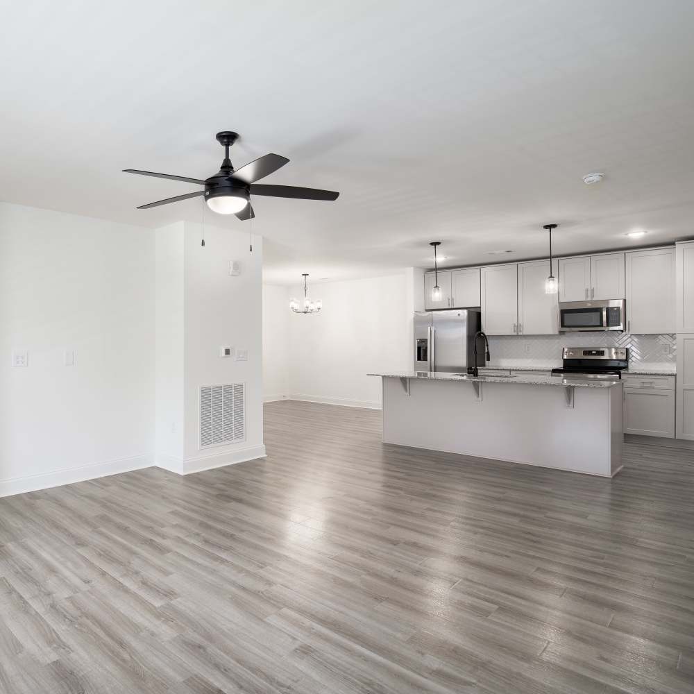 Living room with ceiling fan and connecting kitchen at Retreat at Redstone in Crestview, Florida