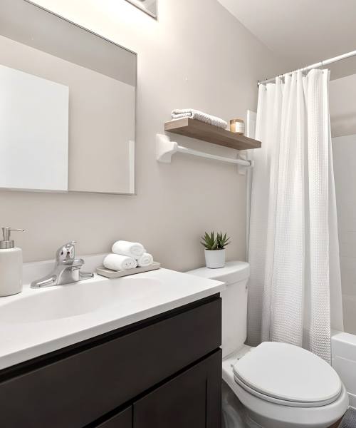 Modern bathroom with white countertops at Pleasant View Townhomes in Baltimore, Maryland