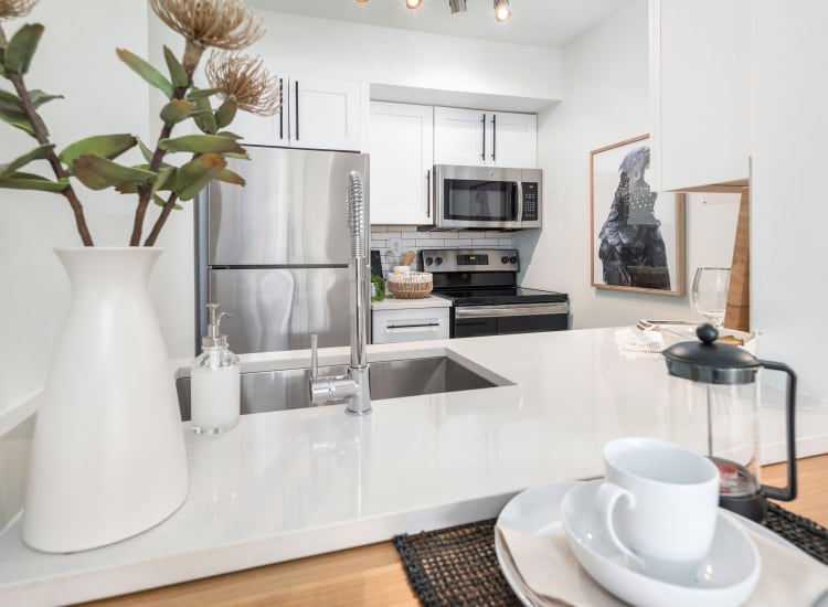 Flowers on the coffee table and hardwood-style floors in a model home at Mezza in Jacksonville, Florida