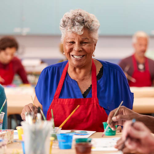 Resident smiling in an art class at Oxford Vista Wichita in Wichita, Kansas