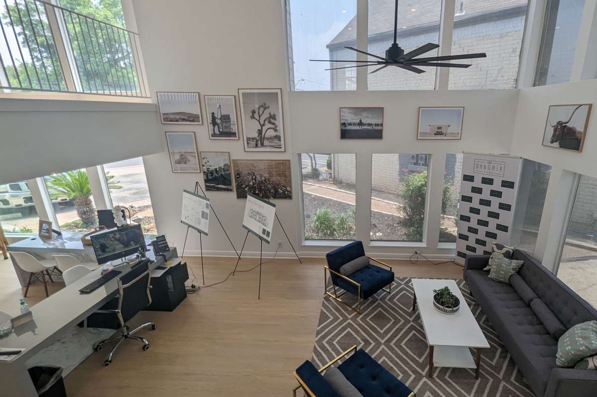 Bright and modern living space with soaring ceilings and large windows showcasing lush landscaping at Sangria Park in Austin, Texas.