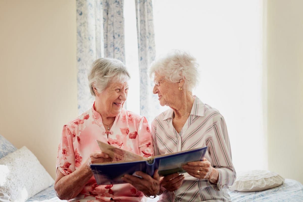 Residents looking at a photo album together at The Commons at Dallas Ranch in Antioch, California