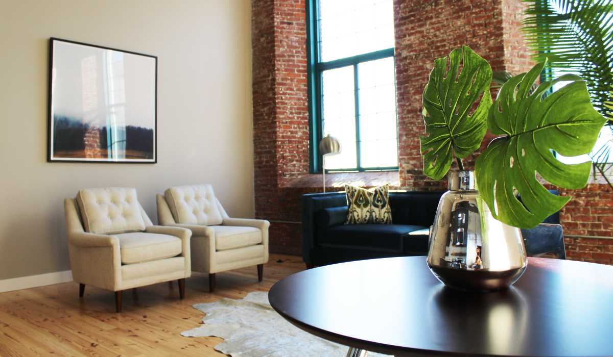 Luxury two chairs face a coffee table with a at Commonwealth Landing Lofts in Fall River, Massachusetts